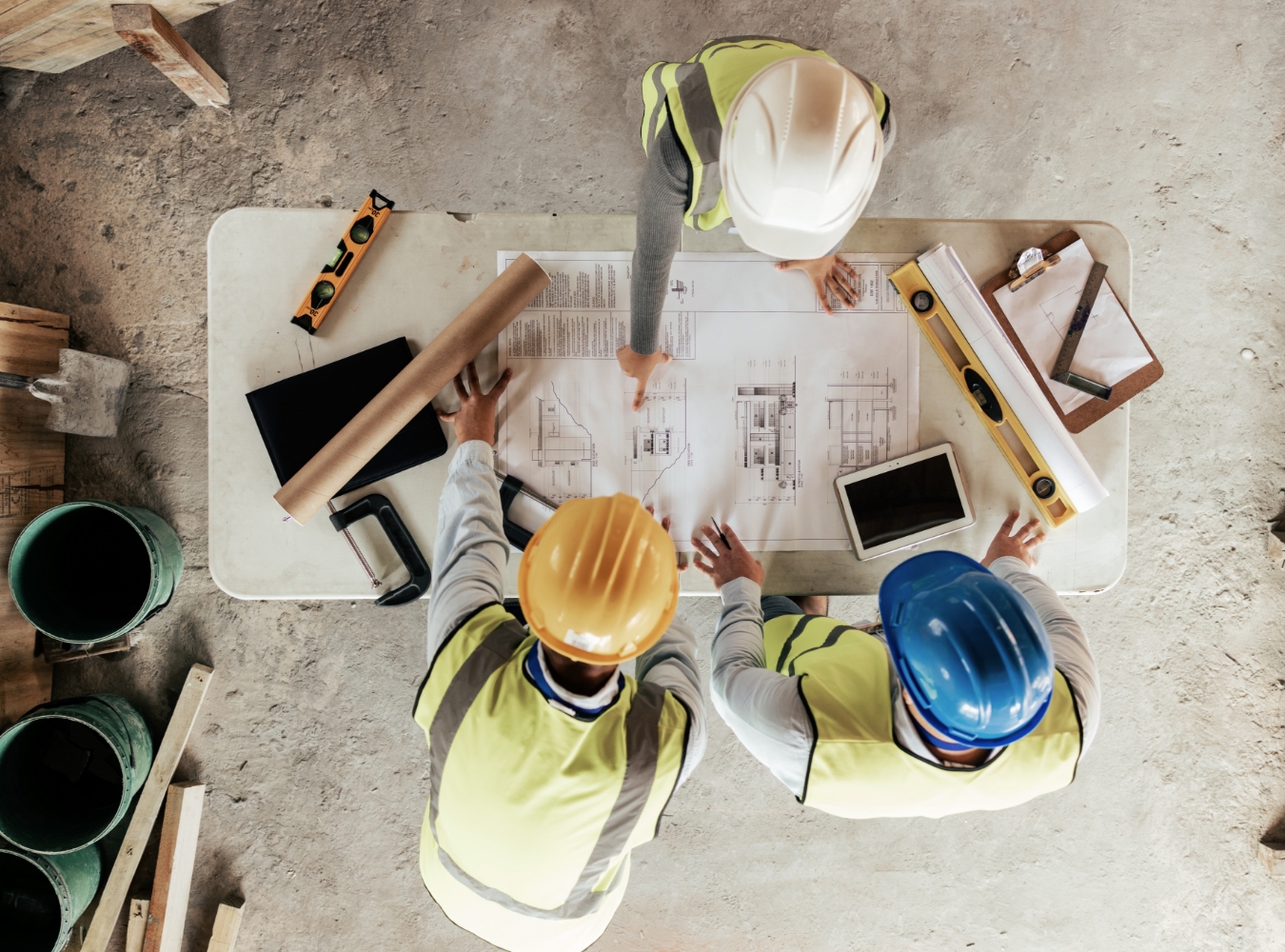 Construction team reviewing blueprints at a jobsite table