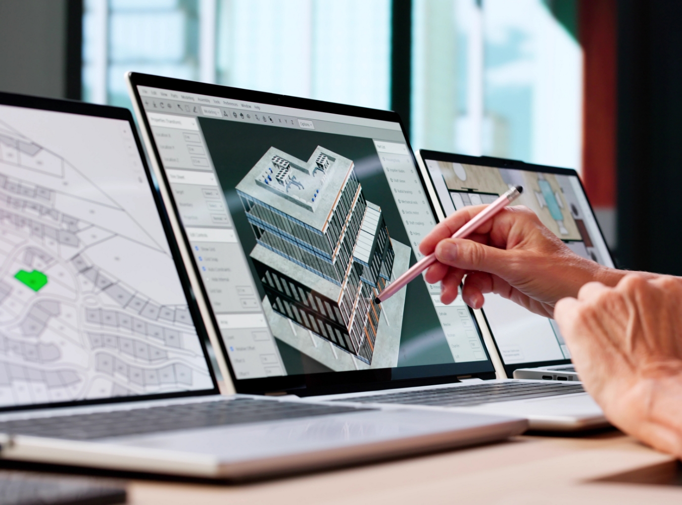 Digital building model displayed on laptops during a design review