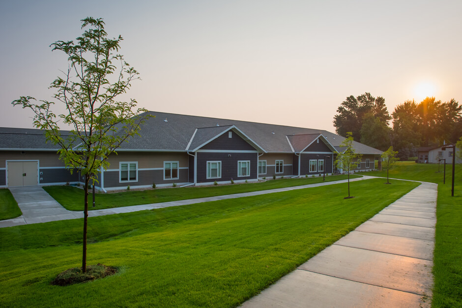 Johnson Memorial Health Services housing exterior with sidewalk and landscaped lawn