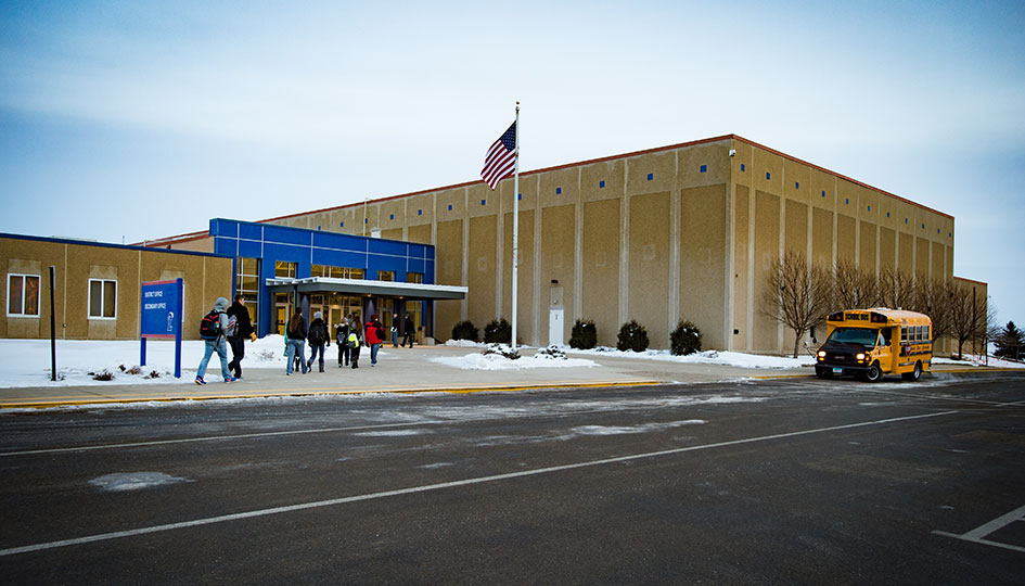 Exterior of Lakeview Schools with students and school bus outside