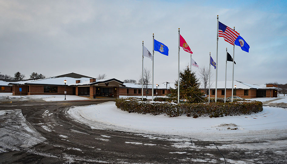 Minnesota State Veterans Home exterior with flags and snowy driveway
