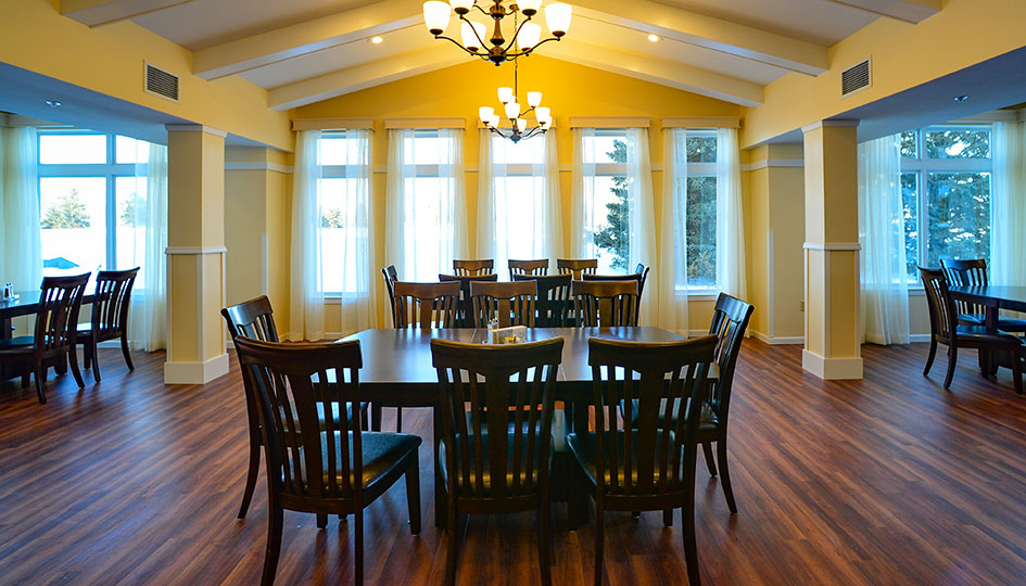 Ortonville independent living dining room with wood flooring and large windows