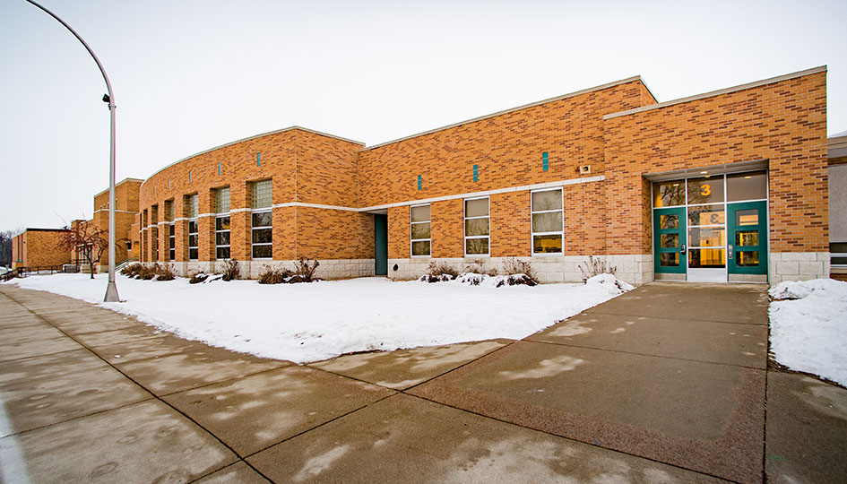Brick exterior of Ortonville Public Schools with entrance and sidewalk