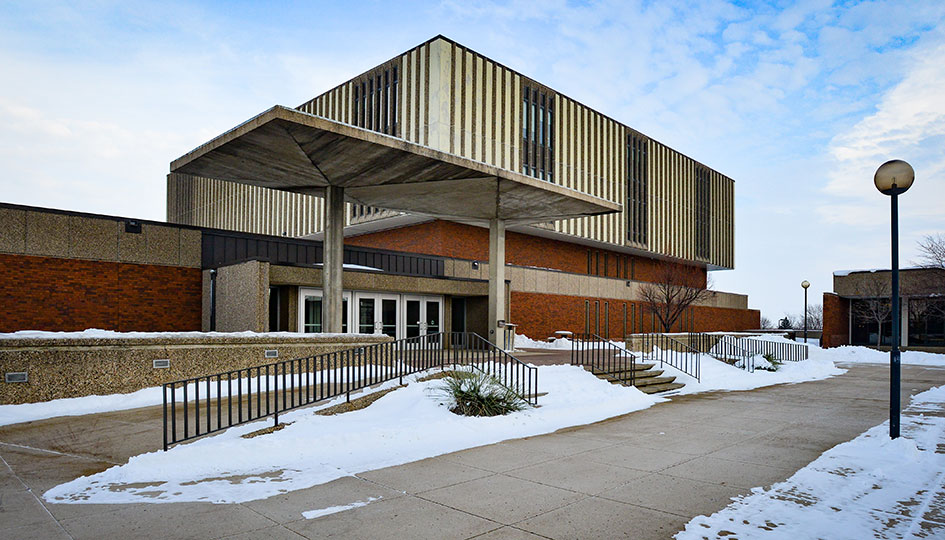 Exterior of State University building with covered entrance and snowy walkways