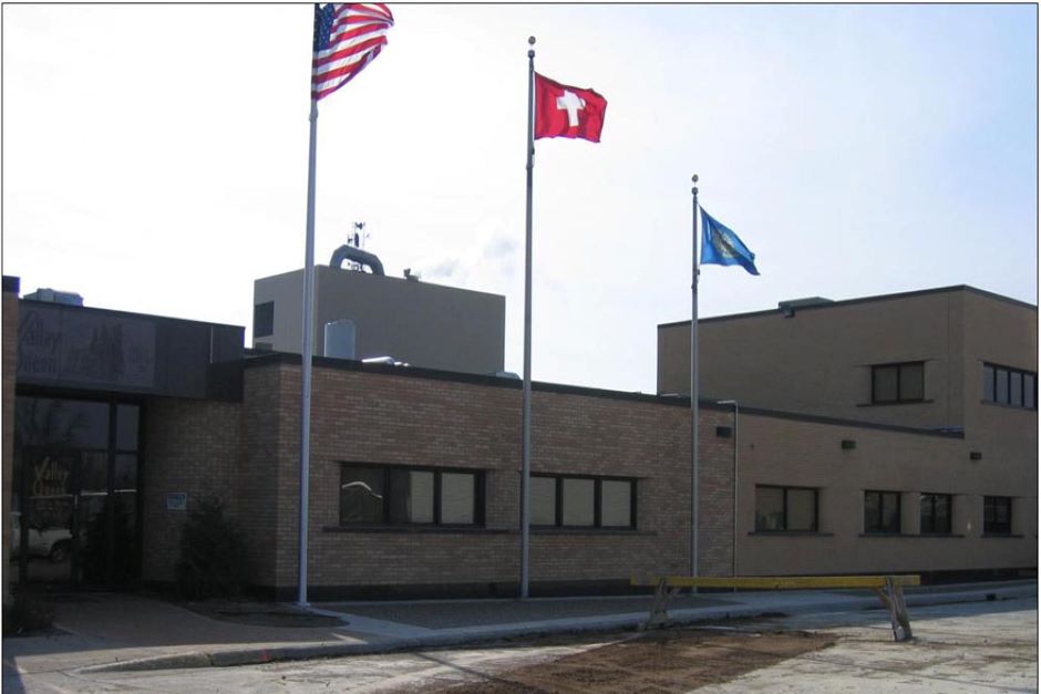 Exterior of Valley Queen Cheese Factory with flagpoles near the entrance